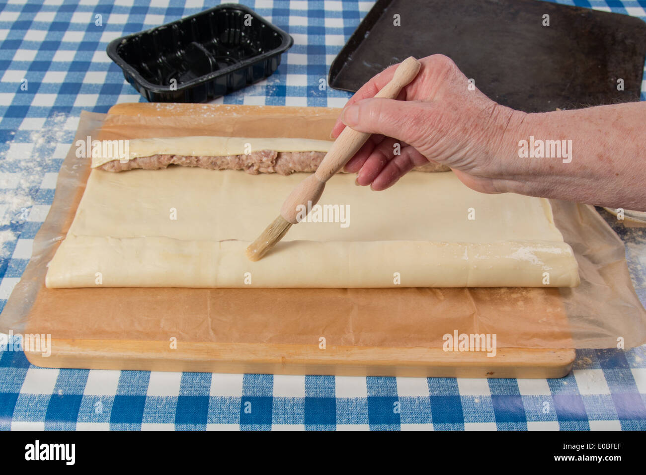 Faire de l'aide de rouleaux de saucisses pâte roulée prête main brossant avec oeuf (11 de 58) Banque D'Images