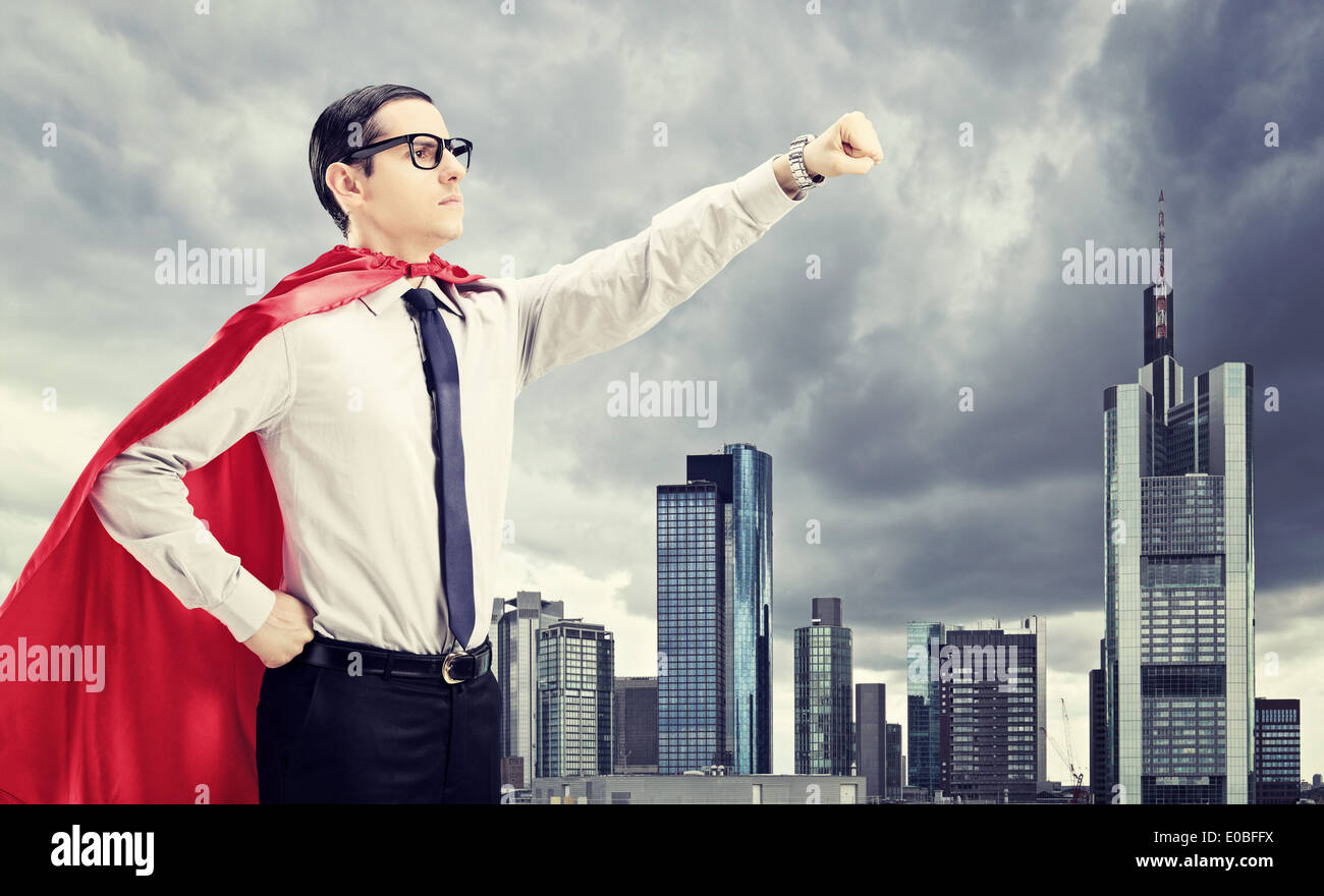 Superhero standing in front of a Dark city avec son poing en l'air Banque D'Images