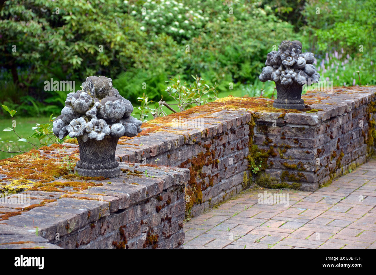 Deux sculptures du semoir de fleurs sur la brique du mur de jardin Banque D'Images