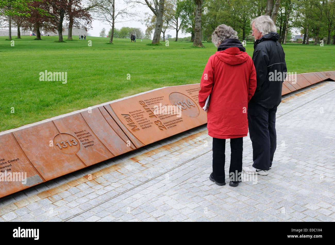 A mature man and woman lire la bataille de Bannockburn temps memorial ligne à la bataille de Stirlingshire, en Écosse. Banque D'Images