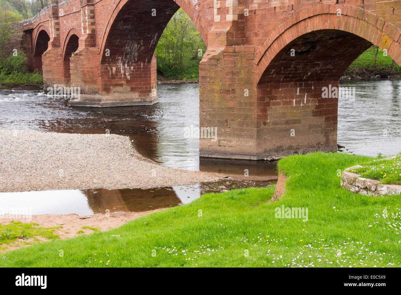 Un vieux pont en grès rouge de l'autre côté de la rivière Eden à Kirkoswold, Cumbria, Royaume-Uni. Banque D'Images