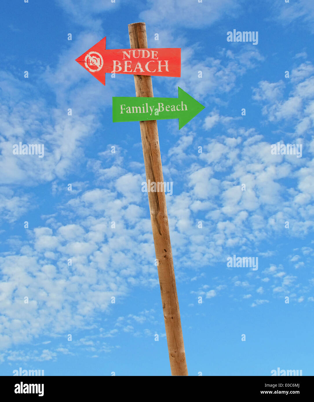 Flèche en bois Panneaux de direction vers le nu et plages familiales contre un ciel bleu Banque D'Images