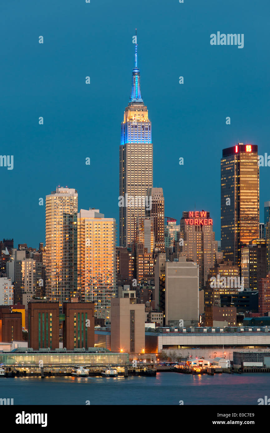 L'Empire State Building, au crépuscule, avec la lueur orange du ciel de l'ouest reflète dans les fenêtres des bâtiments. Banque D'Images