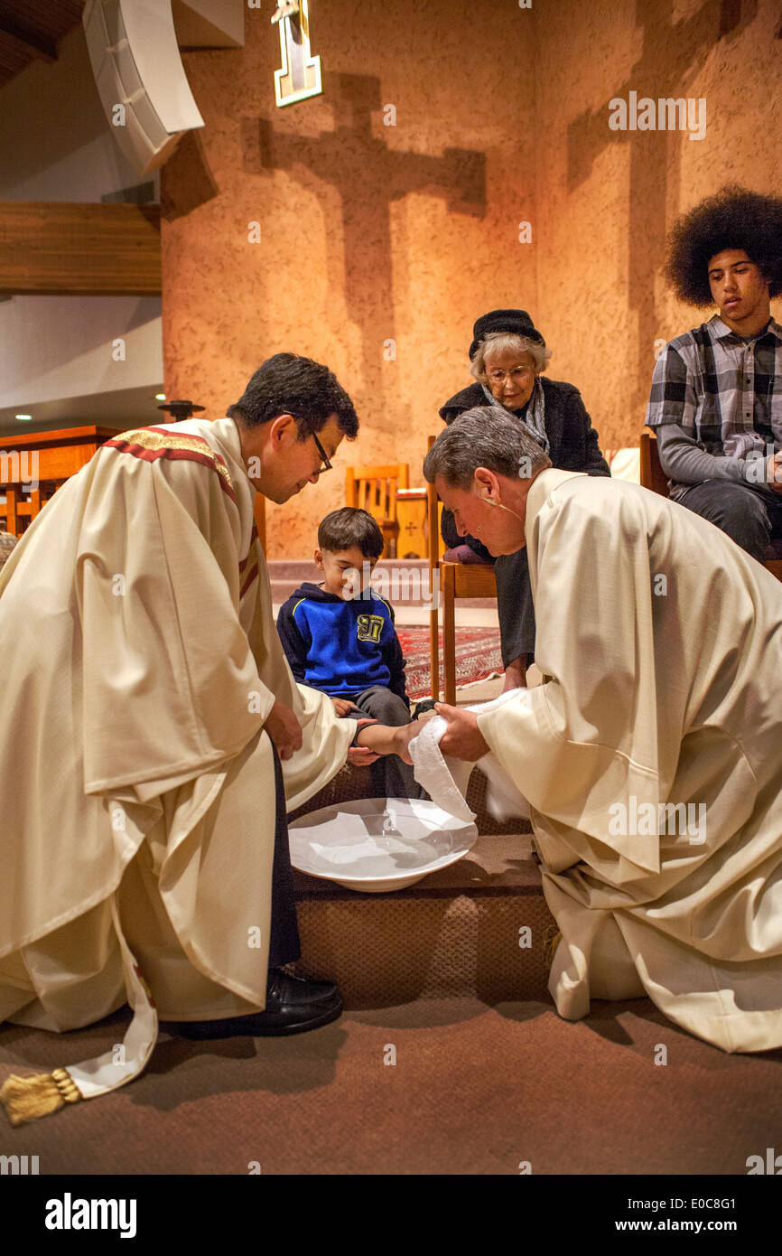 La robed pasteur de l'Église catholique saint Timothée, Laguna Niguel, CA, lave les pieds d'un jeune paroissien le Jeudi Saint Messe en mémoire du Christ lavant les pieds de ses disciples à la Dernière Cène. Remarque d'âge. Banque D'Images