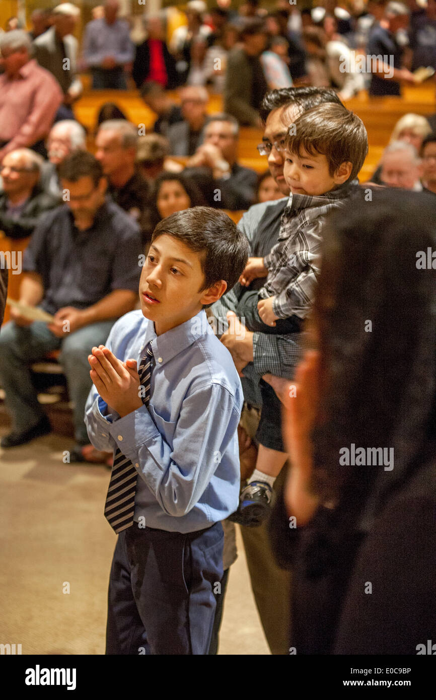 Bien habillés d'un jeune paroissien Hispanique à l'Église catholique de Timothy's, Laguna Niguel, CA, attend dans la ligne de la communion à la fin de la masse. Remarque plus jeune frère à droite. Banque D'Images