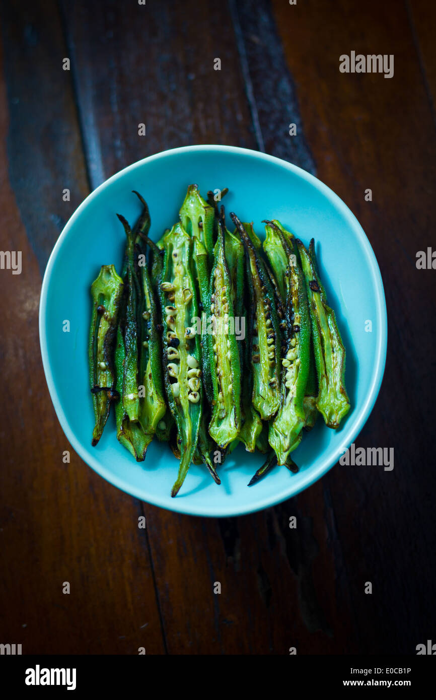 [Sauté de Okra] fendues cleave [le long de la longueur] frites avec de l'huile [lay mis sur] la [couleur cyan pâle food plate] Banque D'Images