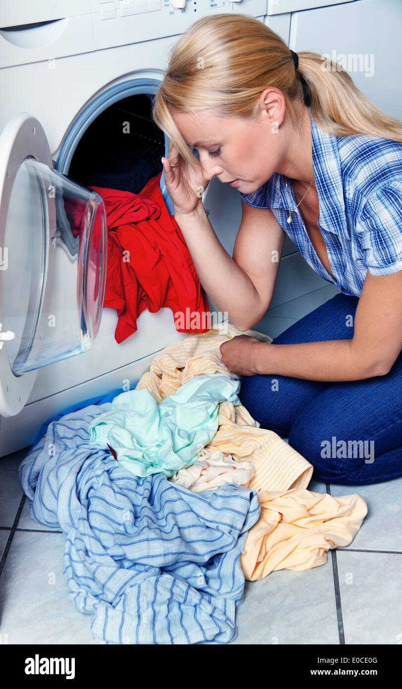Une jeune femme au foyer avec lave-linge et la lessive. Lave-jour., eine junge Hausfrau und mit Waesche. Waschtag. Banque D'Images