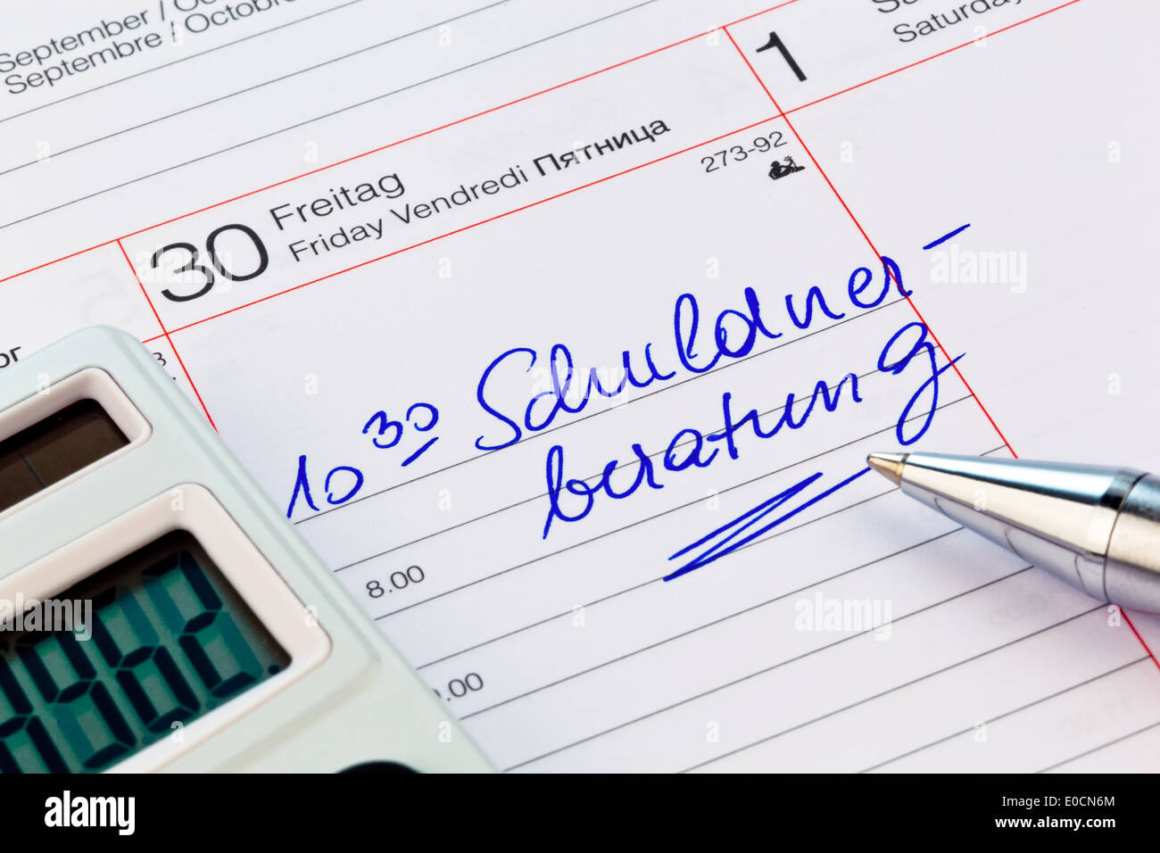 Consultation du débiteur dans un calendrier. Photo symbolique pour la lutte contre la pauvreté et la faillite privée Banque D'Images
