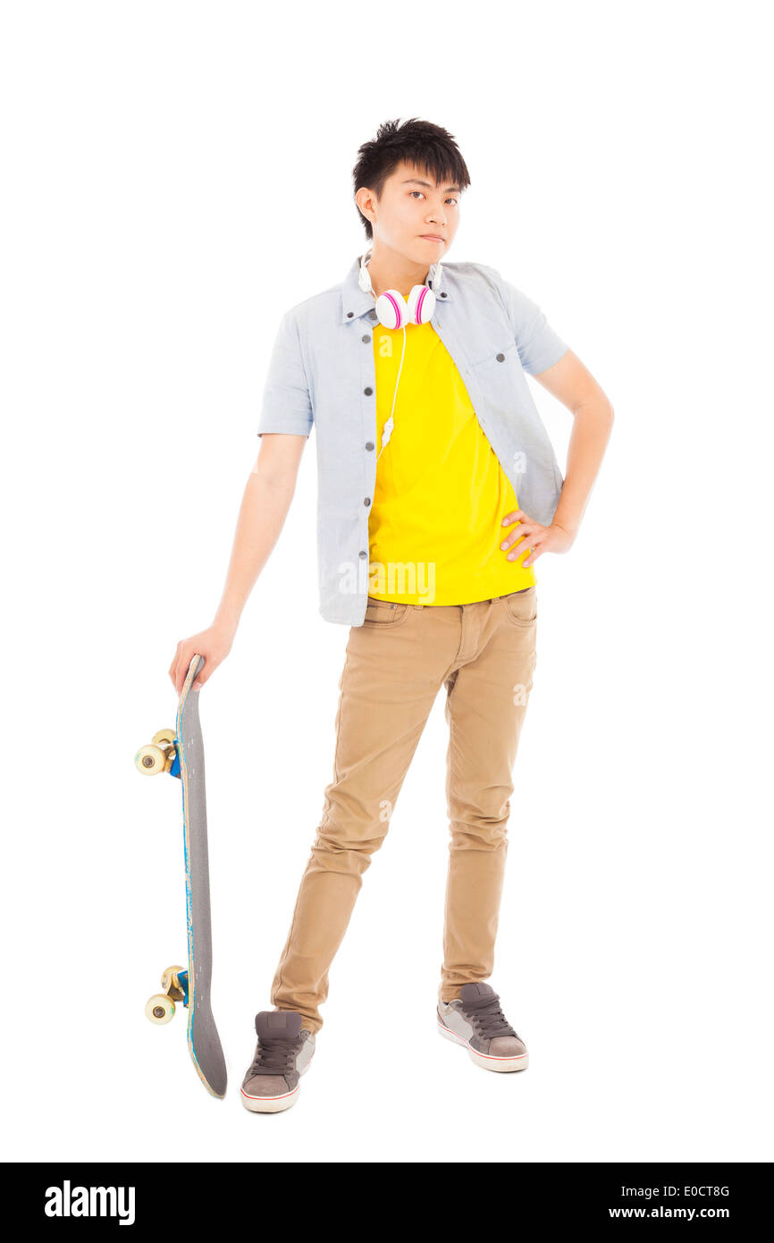 Jeune homme funky debout et tenant un skateboard Banque D'Images