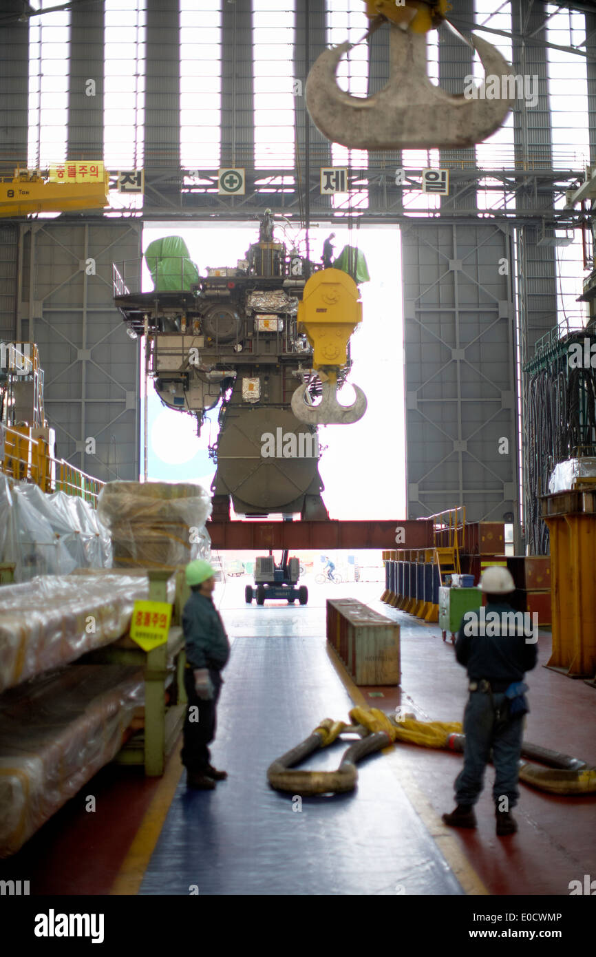 L'homme le moteur à deux temps dans le hall de production avant le transport, la production modulaire au plus grand chantier naval, Hyundai Heavy Banque D'Images