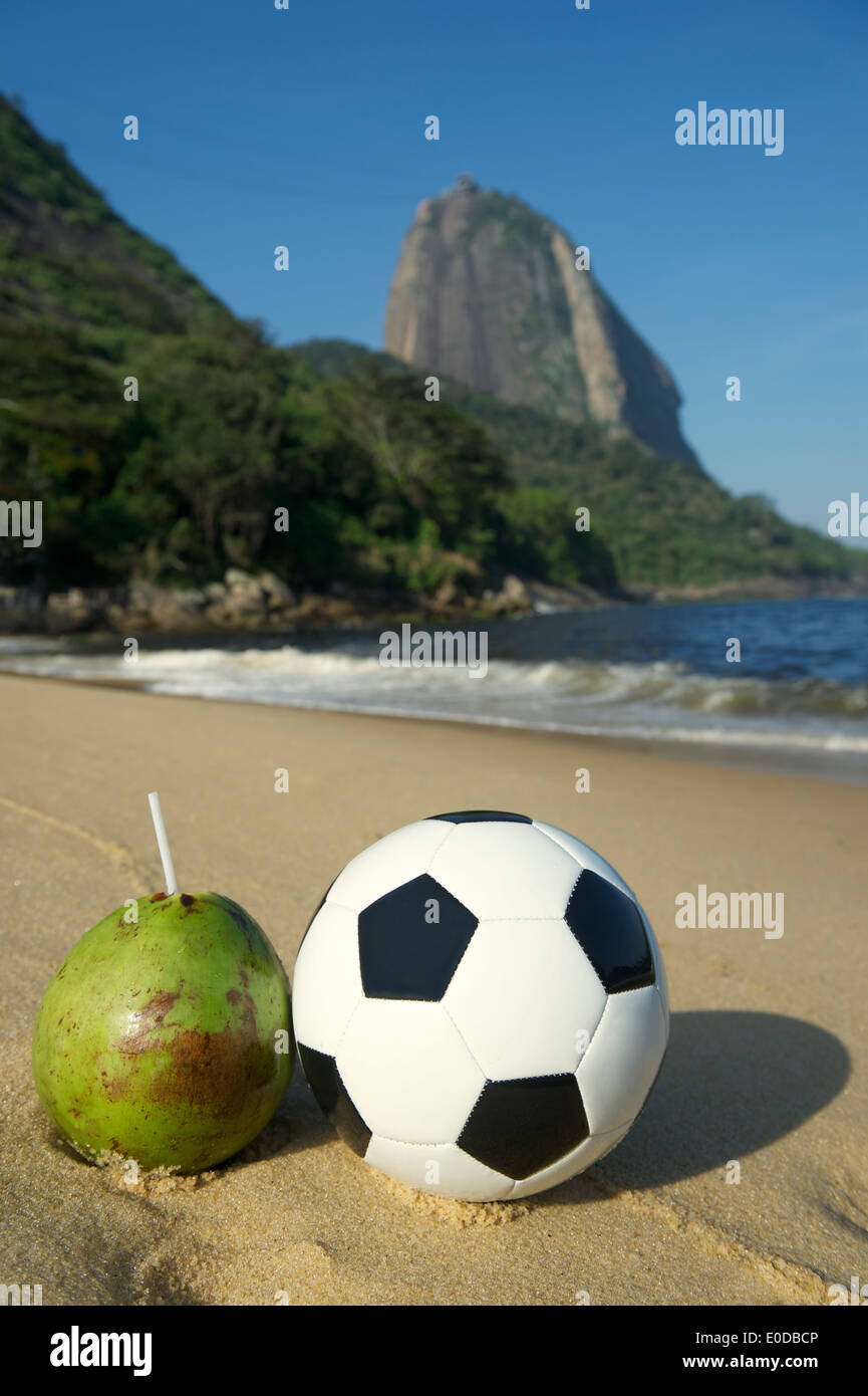 Ballon de soccer de football vert frais debout à côté de la noix de coco Coco verde gelado potable Plage Rouge Pain de Sucre Rio de Janeiro Banque D'Images