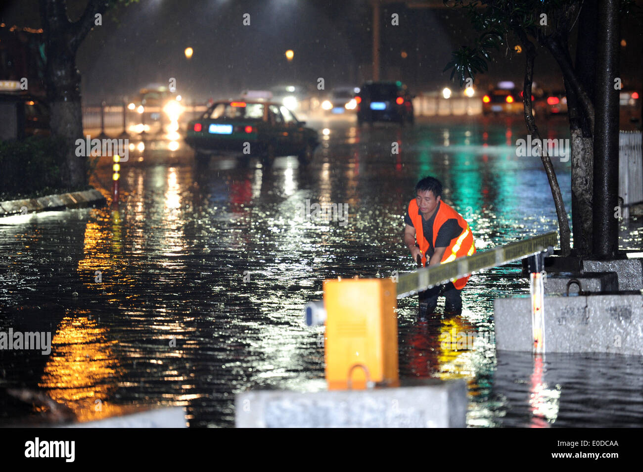 Guiyang, dans la province du Guizhou en Chine. 10 mai, 2014. Un travailleur de la ville efface sorties de purge d'une rue dans les inondations à Guiyang, dans la province du Guizhou en Chine du sud-ouest, le 10 mai 2014. De fortes pluies et de grêle ont touché certaines régions de la province de la fin vendredi. © Tao Liang/Xinhua/Alamy Live News Banque D'Images