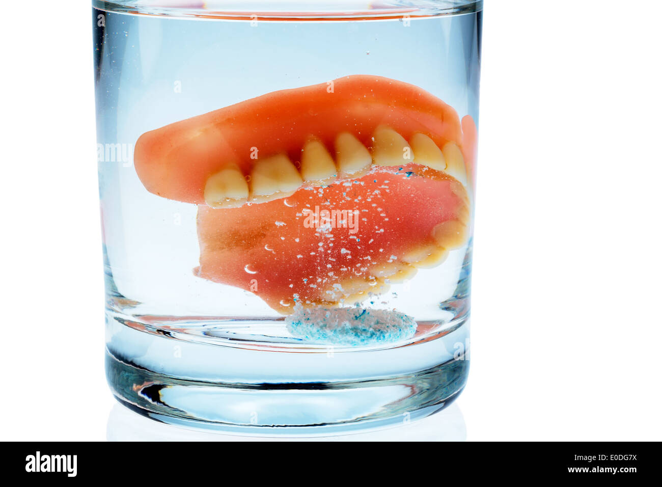 Un ensemble de prothèses est nettoyé dans un verre avec de l'eau. Droit de l'hygiène., Ein Zahnersatz wird einem Glas mit Wasser gereinigt. Riche Banque D'Images