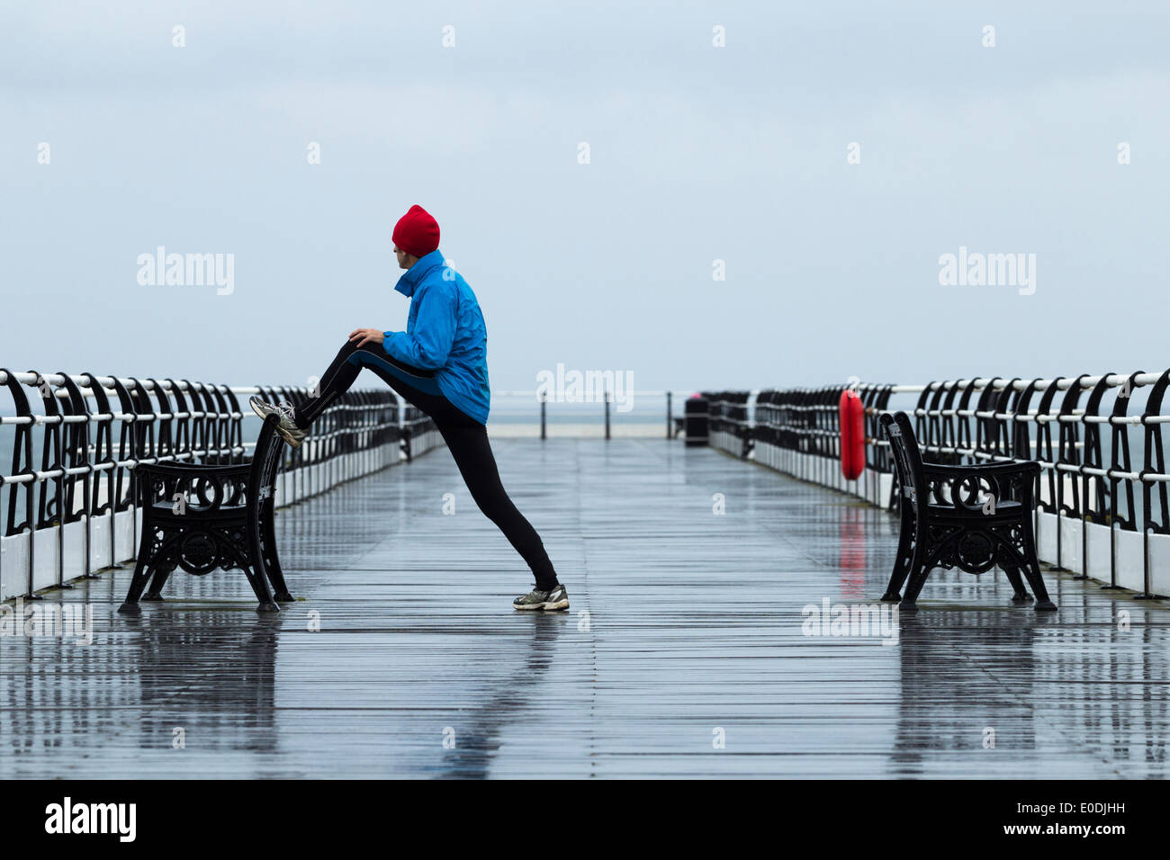 Jogger stretching sur Sltburn pier. Marseille par la mer. Yorkshire du Nord. UK Banque D'Images