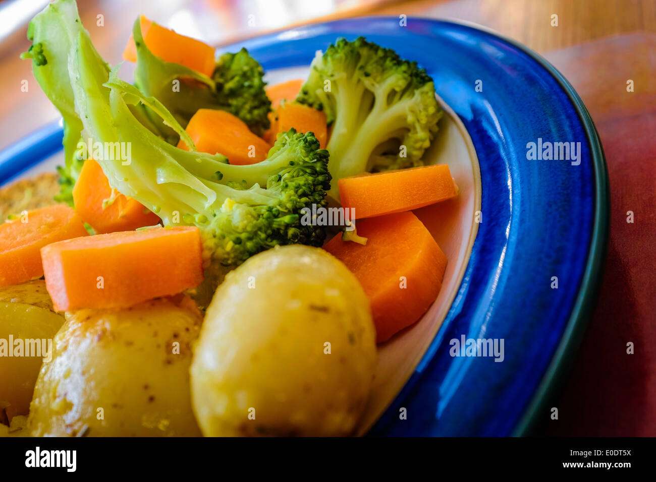 Le brocoli, les carottes en rondelles et les pommes de terre sur une plaque bleue. Close up close-up closeup nourriture saine alimentation légumes légumes Banque D'Images