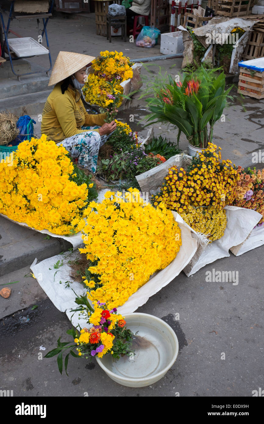 Marchande de fleurs au marché de Hoi An Banque D'Images