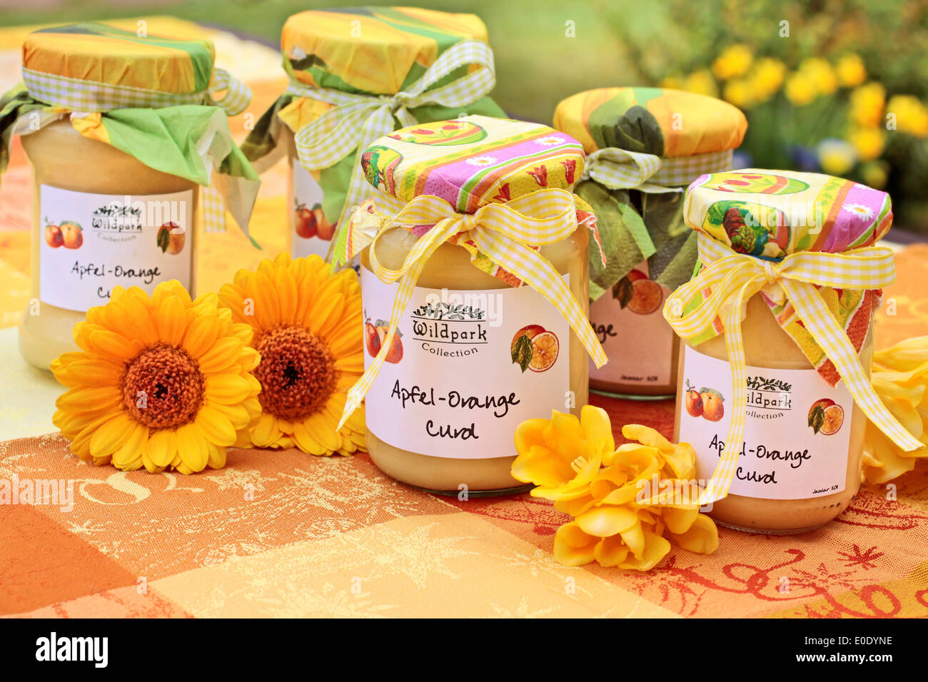 Orange Apple curd sur une nappe de fleurs colorées Banque D'Images