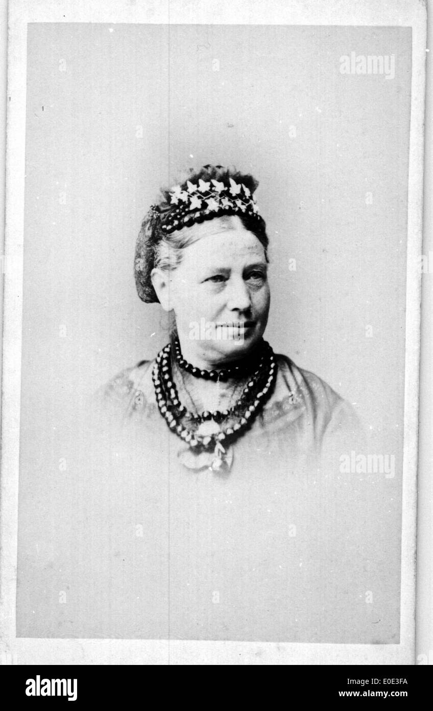 Portrait d'une femme âgée, capturé dans une photographie vintage en noir et blanc. L'image reflète les styles de mode et de portrait du début du XXe siècle. Banque D'Images