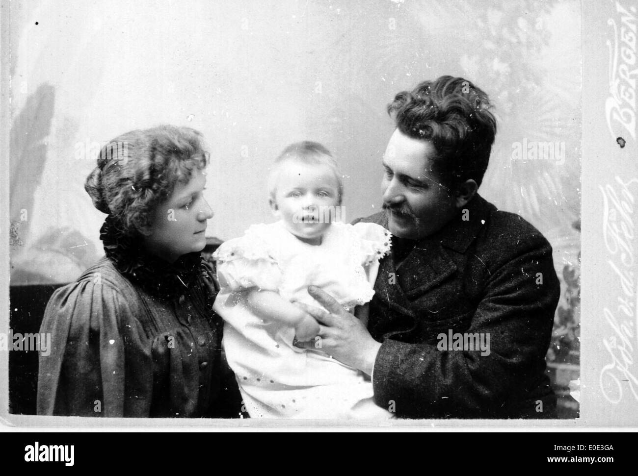 Portrait vintage en noir et blanc d’une famille mettant en scène un couple avec leur enfant, capturé dans un moment intemporel. Cette photo illustre la vie de famille et les portraits du début du XXe siècle. Banque D'Images