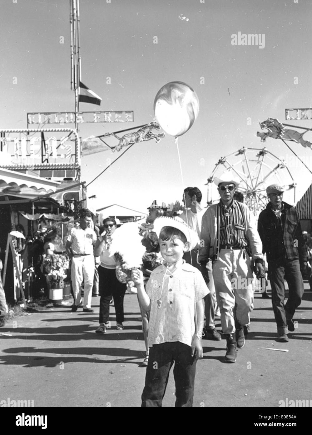 Une image historique de l'exposition Lethbridge and District, mettant en valeur le milieu animé pendant l'événement. La photo reflète l'atmosphère vibrante de l'exposition, avec les visiteurs appréciant diverses attractions et divertissements. Banque D'Images
