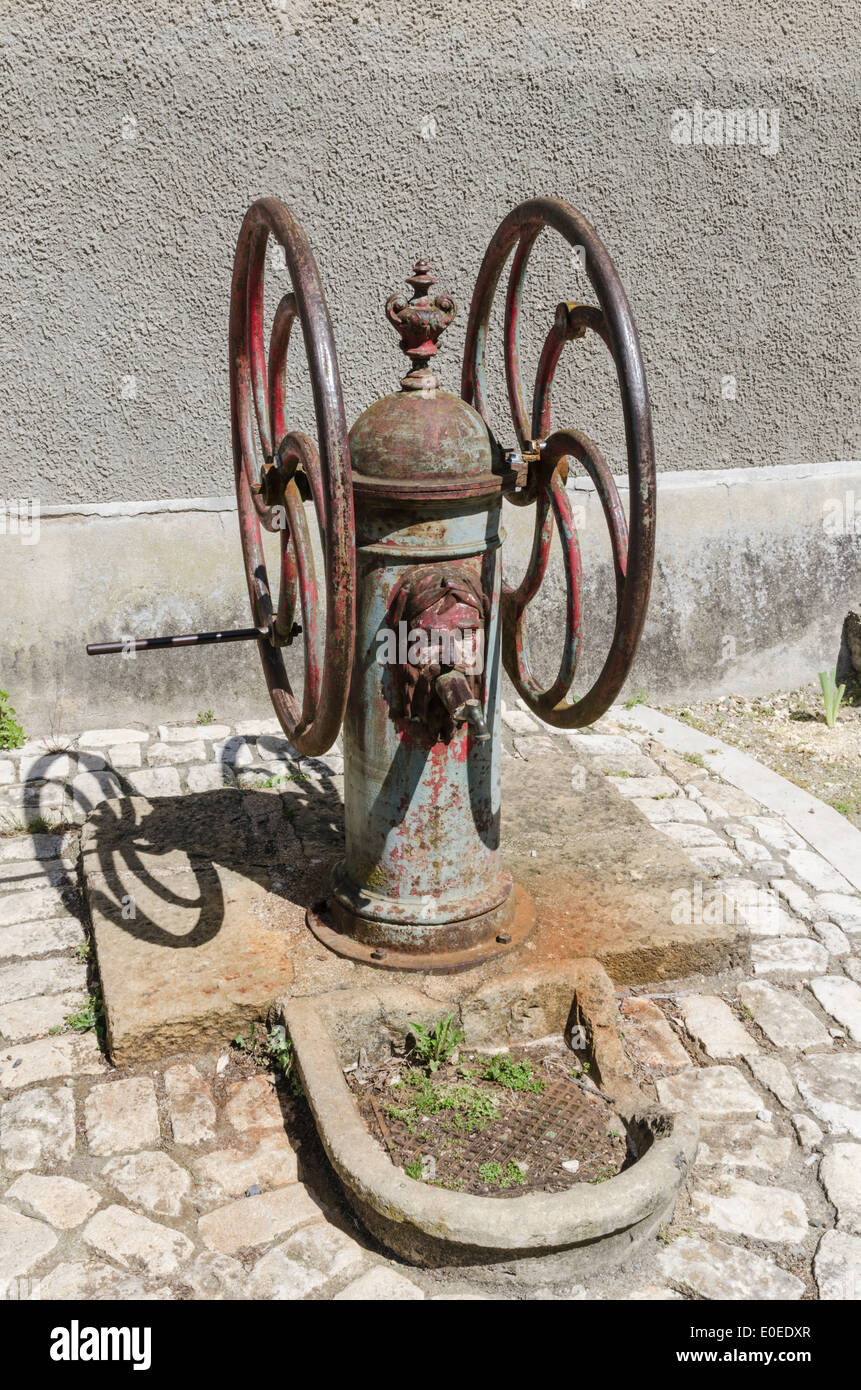 Une ancienne fonction d'un robinet d'eau à l'extérieur de l'Église de Saint-Sauveur dans la ville médiévale de Saint-Macaire, Gironde, France Banque D'Images