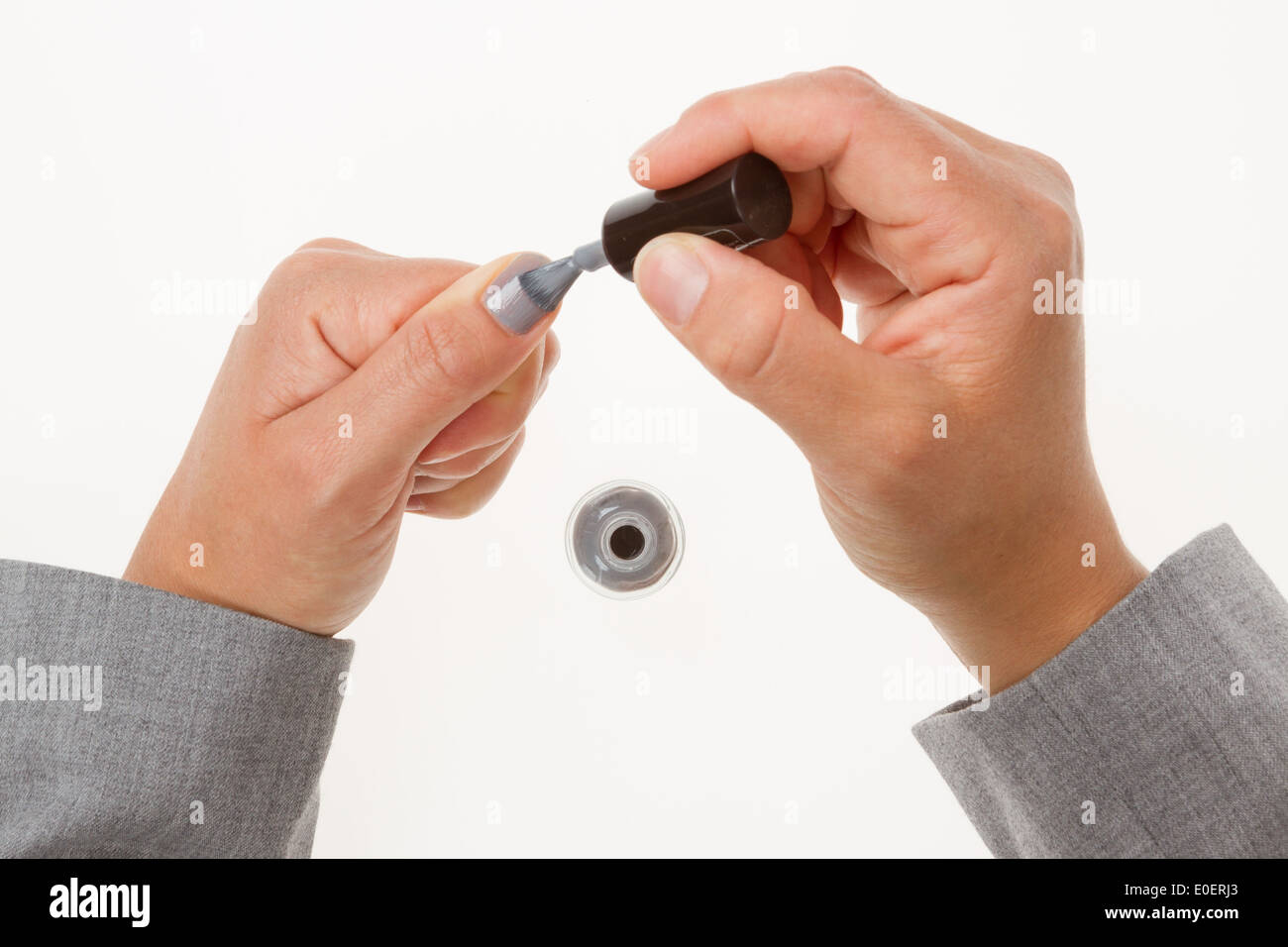 Les ongles avec peinture émail gris gros plan sur fond blanc Banque D'Images