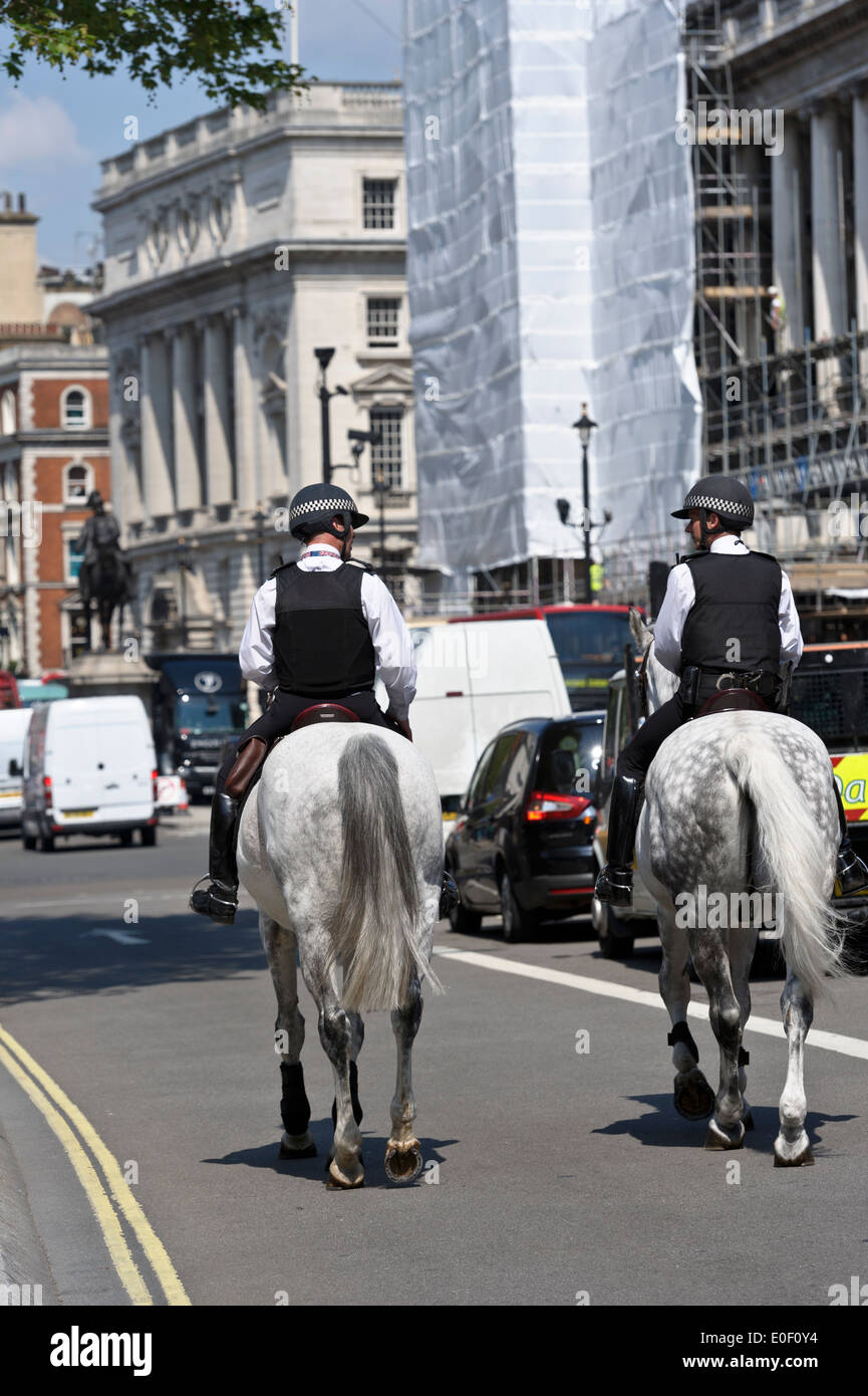 Deux officiers de la Police montée patrouille dans la rue de Londres, Angleterre, Royaume-Uni. Banque D'Images