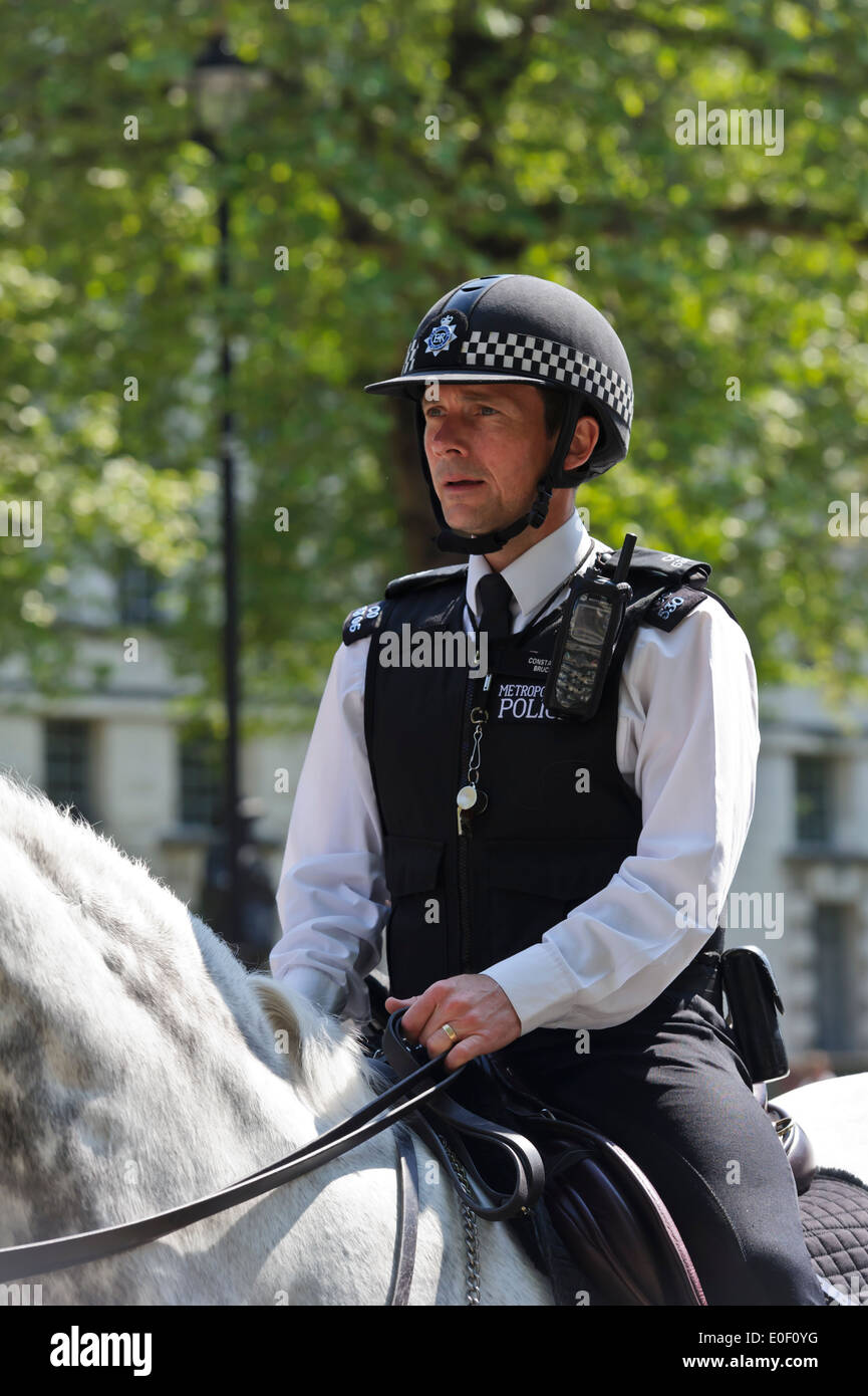 Un officier de la Police montée patrouille dans la rue de Londres, Angleterre, Royaume-Uni. Banque D'Images