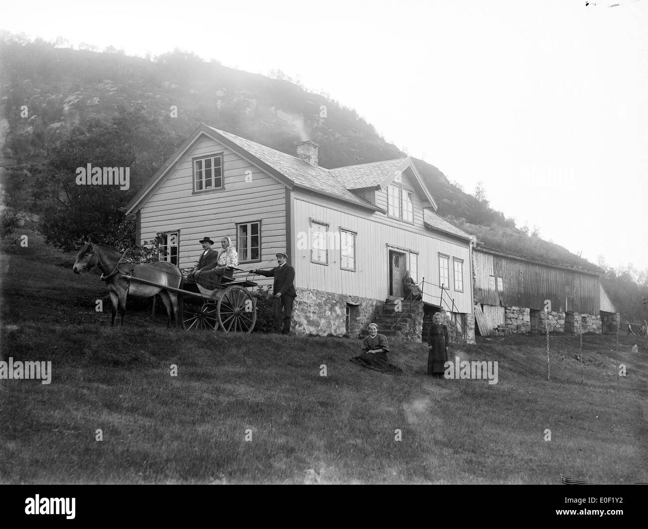 Photographie historique d'une ferme dans l'ouest de la Norvège, prise entre 1890 et 1910. La photo montre la vie agricole traditionnelle, y compris des outils agricoles et un chariot de cette époque. Banque D'Images