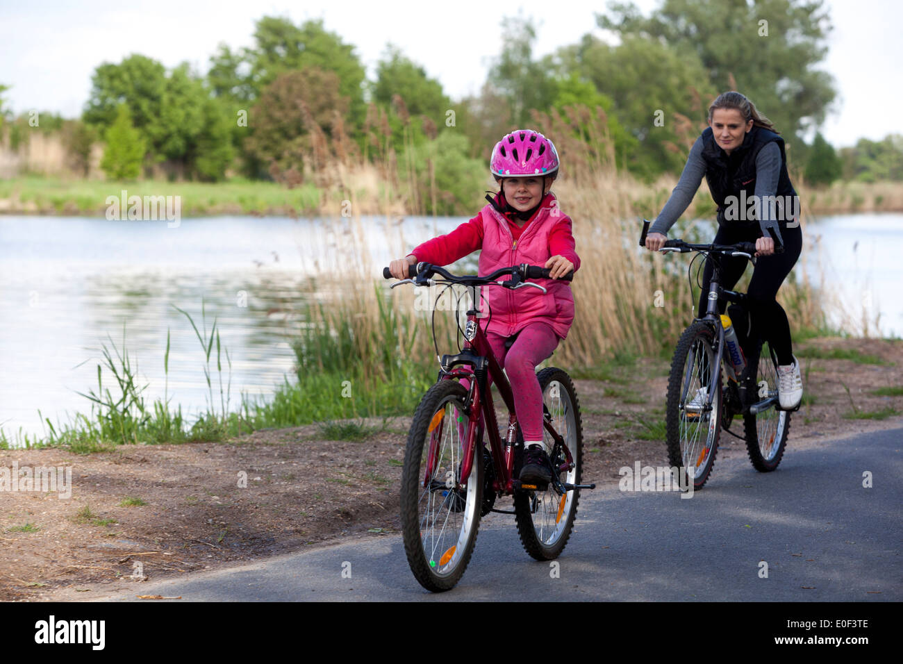 Les gens de la famille ride un casque de vélo, sur la piste cyclable le long de la rivière de l'Elbe Banque D'Images