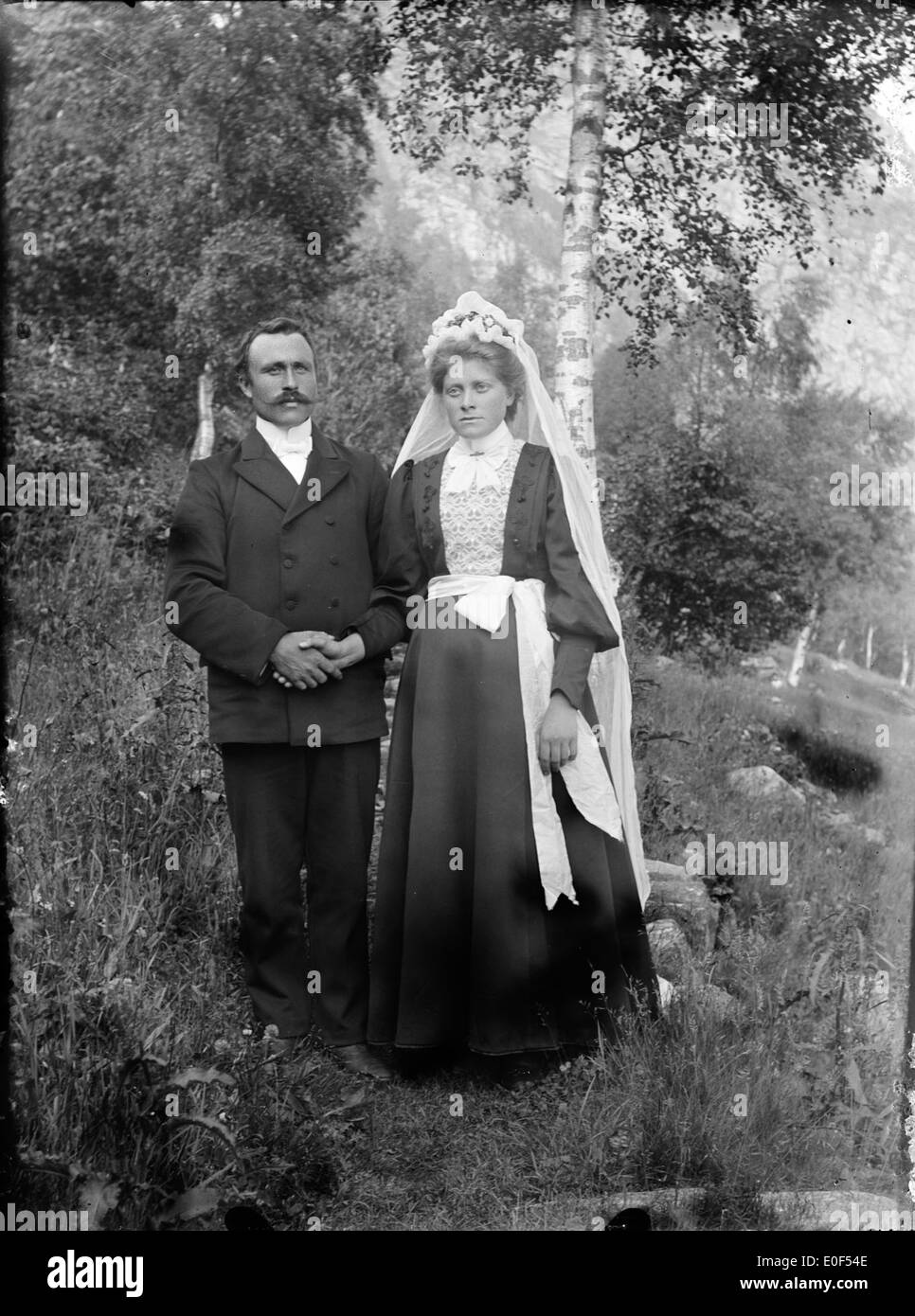 Une photographie de mariage vintage prise en Norvège, mettant en vedette une mariée et un marié dans une tenue traditionnelle. L'image reflète les coutumes historiques de mariage et le patrimoine culturel de la Norvège. Banque D'Images