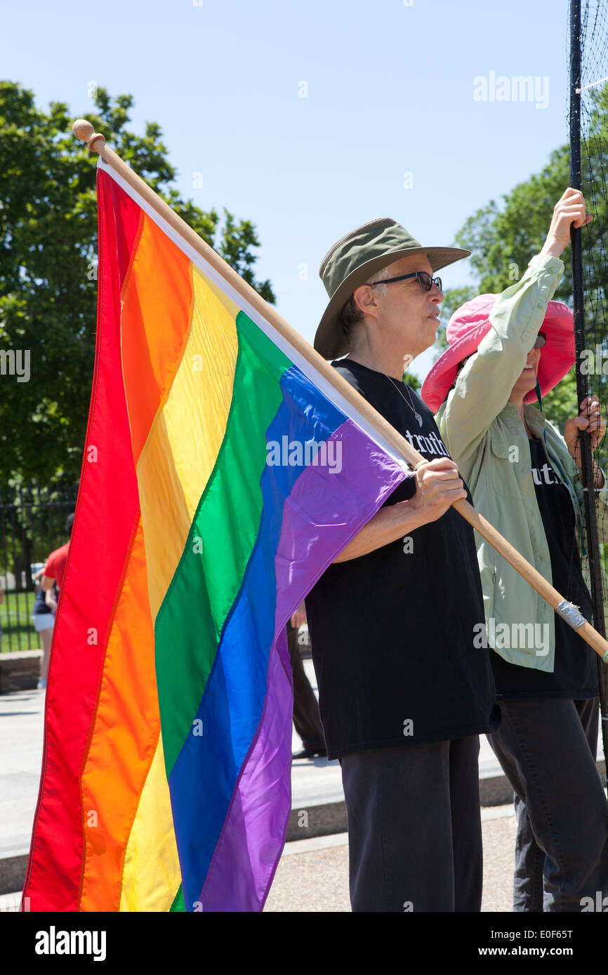 Personne tenant un drapeau arc-en-ciel au rassemblement LGBT - Washington, DC USA Banque D'Images