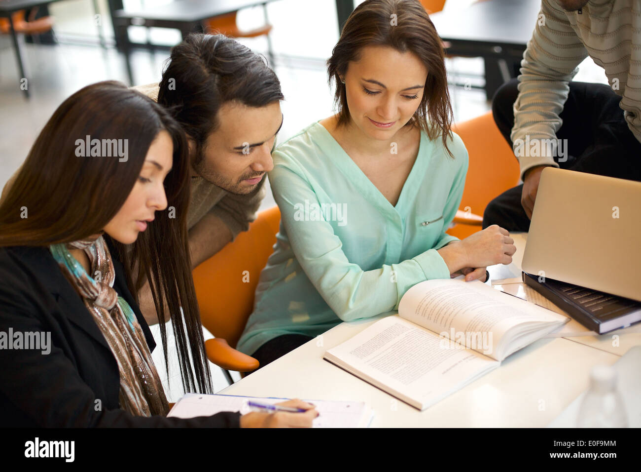 Groupe d'élèves étudiant dans une bibliothèque. Les jeunes gens assis ensemble à la table fonctionne sur le travail scolaire. Banque D'Images