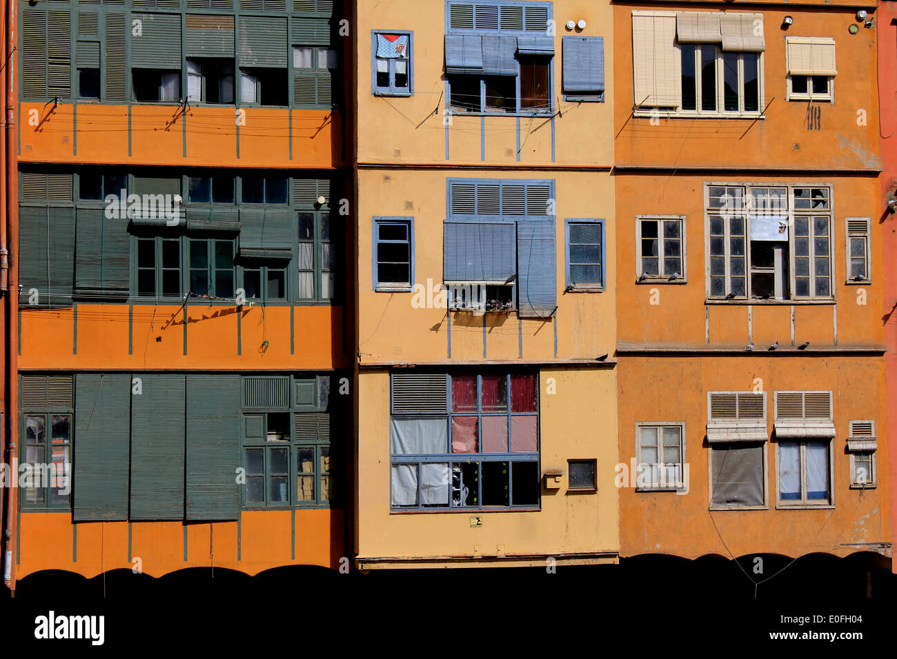 Orange et jaune et les volets des maisons bordant la rivière Onyar, à Gérone, Catalogne, Espagne Banque D'Images