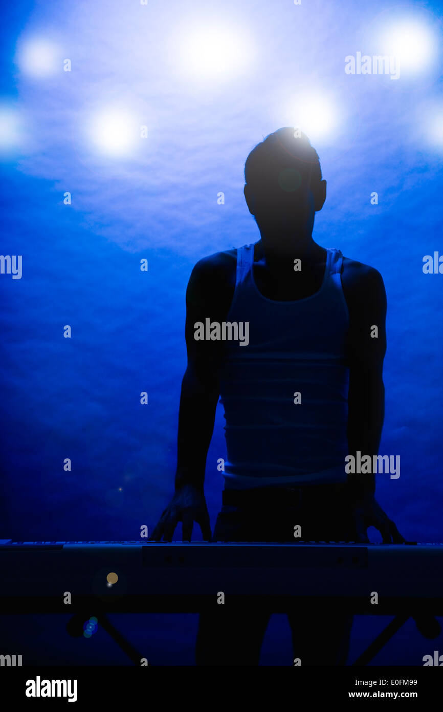 Silhouette d'homme musicien sur scène Banque D'Images