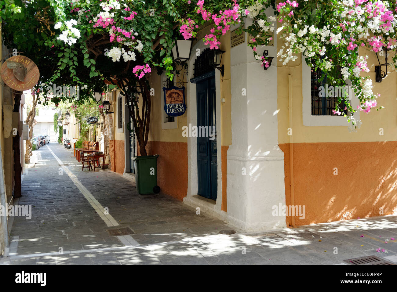 Bougainvilliers rose et blanc offre une verrière colorée sur un sol carrelé en pierre rue arrière. Vieille ville de Rethymnon. La Crète. La Grèce. Banque D'Images