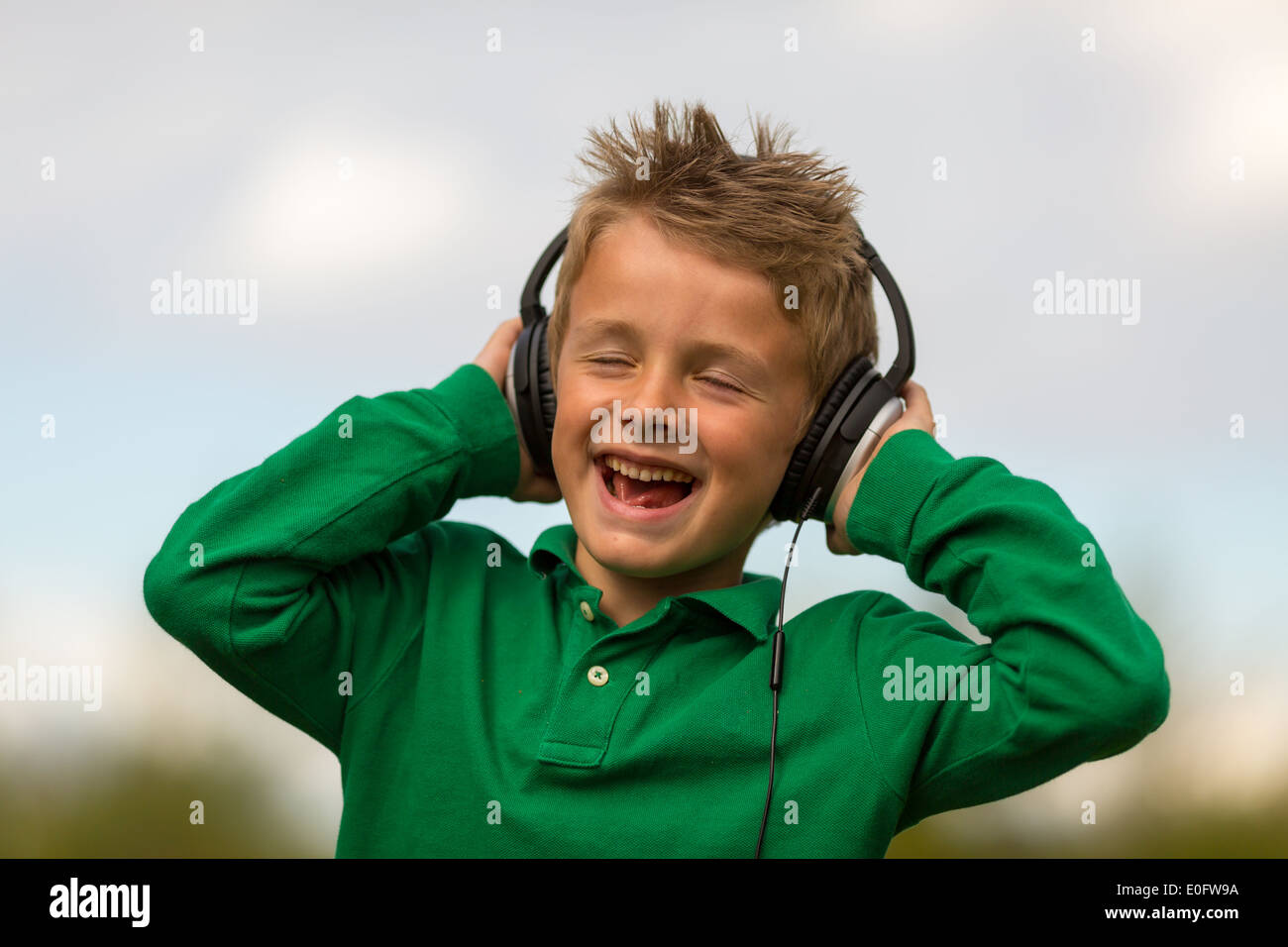 Garçon d'écouter de la musique et chanter. Marques de commerce ont été supprimés. Banque D'Images