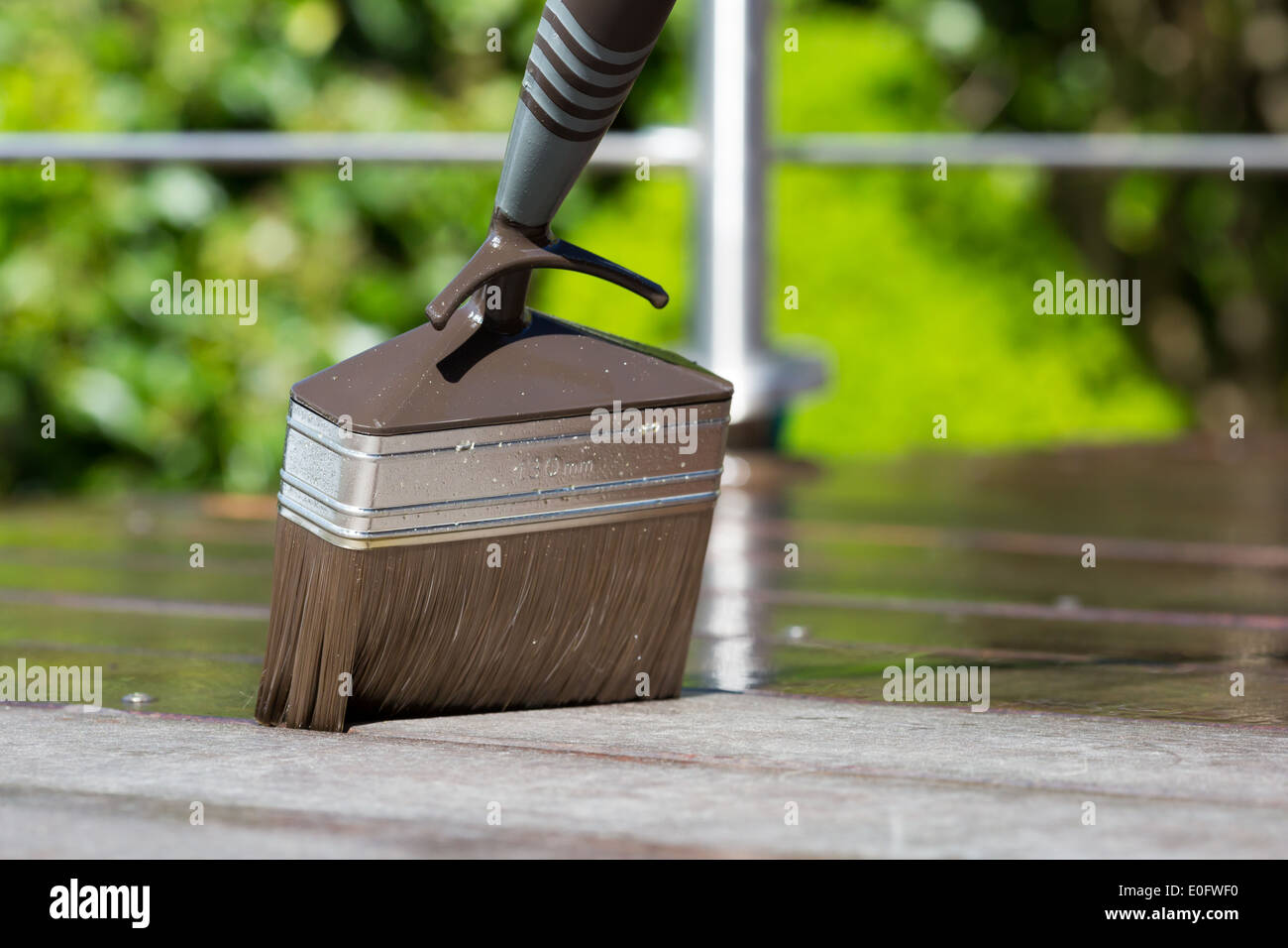 Entretien au printemps du luxe terrasse bois avec brosse et terrasse de l'huile. Banque D'Images