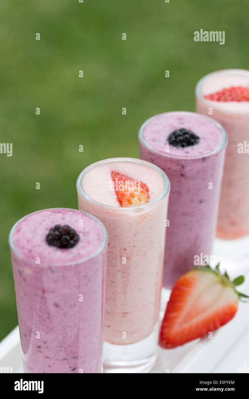 Strawberry et blackberry boissons dans un jardin d'été, servi dans de grands verres sur table blanc Banque D'Images