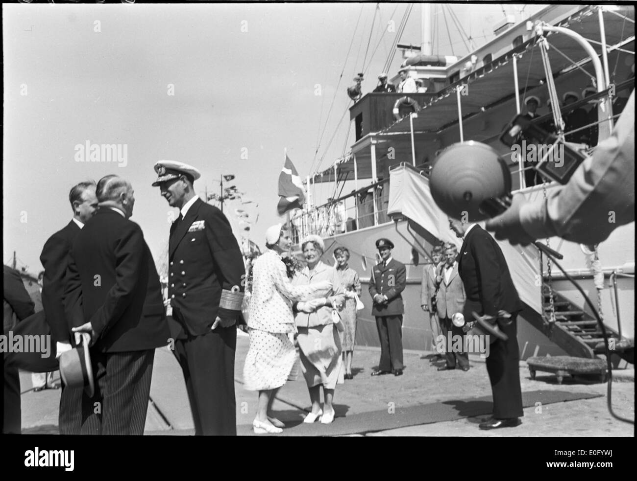 Cette photographie montre le roi Frederik IX et la reine Ingrid du Danemark à bord du yacht royal pendant leurs voyages. L'image capture leur voyage royal, reflétant l'importance de la monarchie danoise et de leurs voyages à bord du navire royal. Banque D'Images