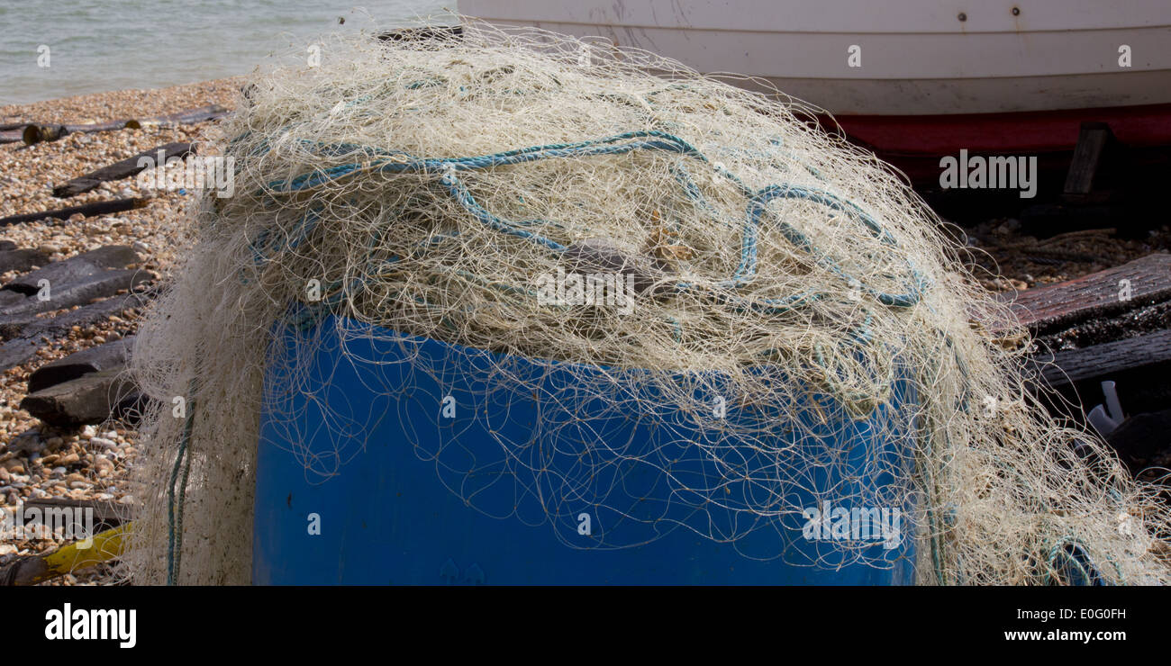 Filets de pêche blanche sur un fond bleu, conteneurs, comprend la partie voile, mer, plage de galets Banque D'Images