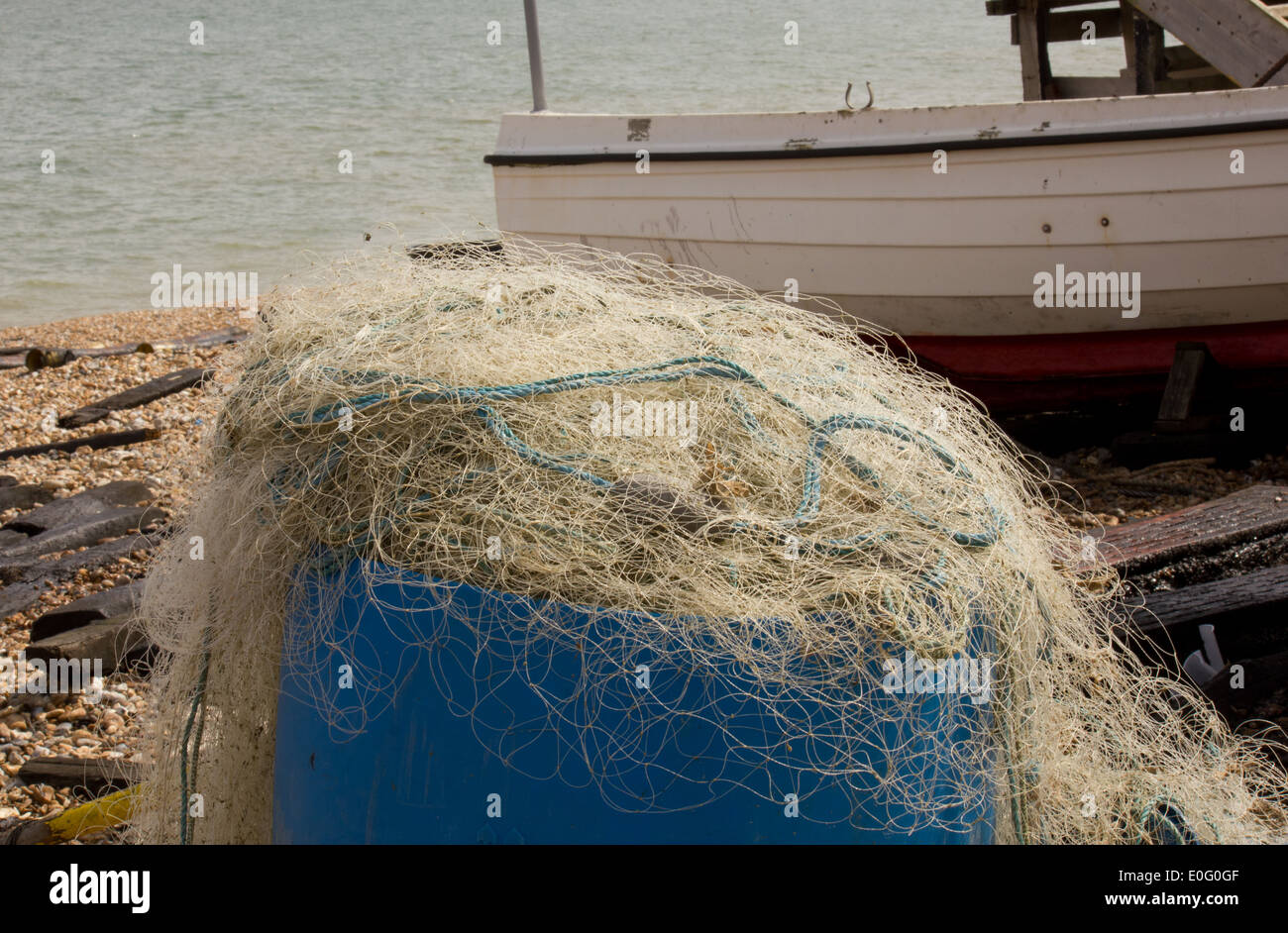 Filets de pêche blanche sur un fond bleu, conteneurs comprend, bateau, mer, plage de galets Banque D'Images