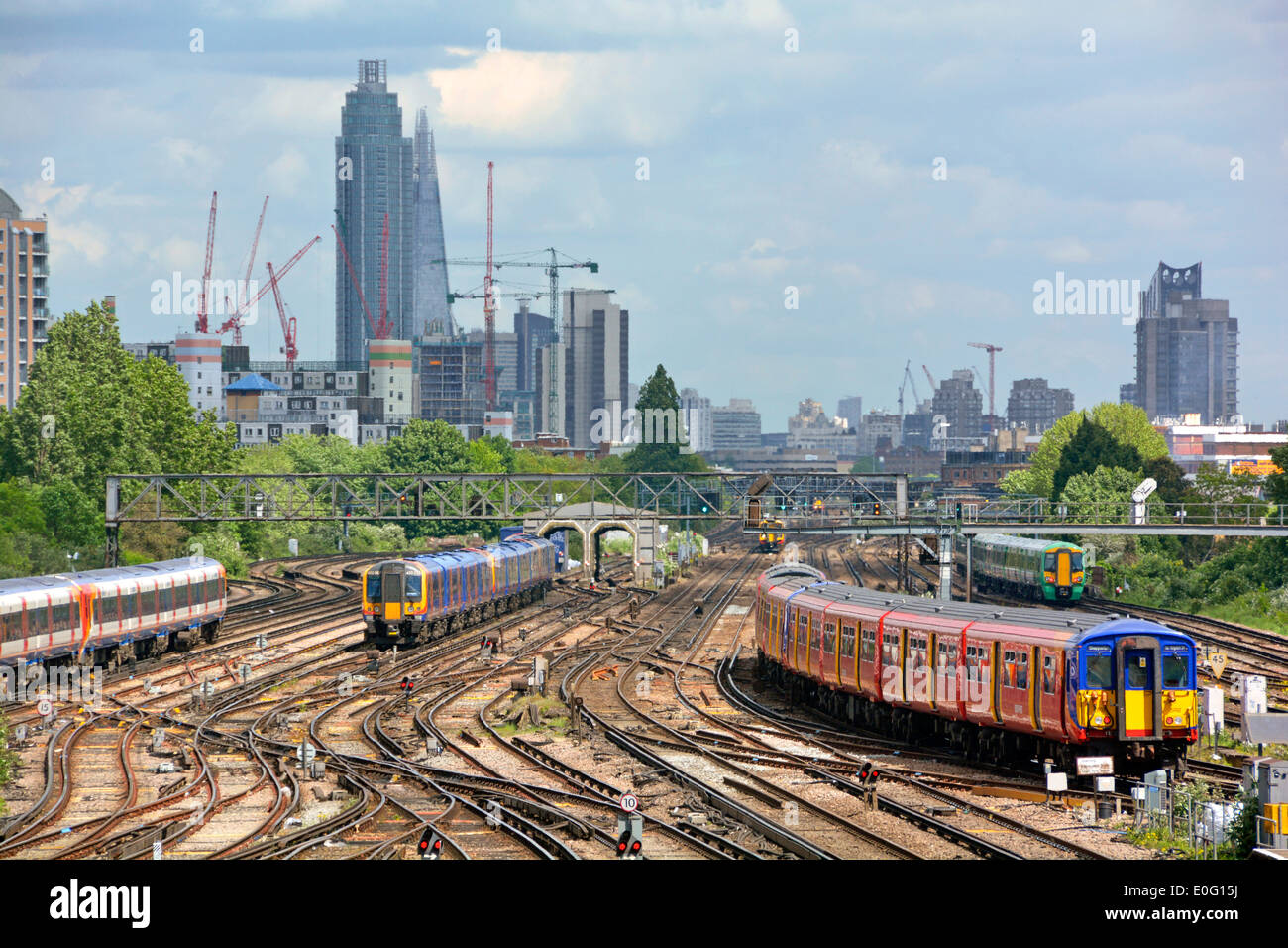 Trains et voies de transport en commun très fréquentés de Clapham Junction avec la tour St Georges Vauxhall et les sites de Shard sur la ligne d'horizon de Londres au-delà de l'Angleterre Banque D'Images