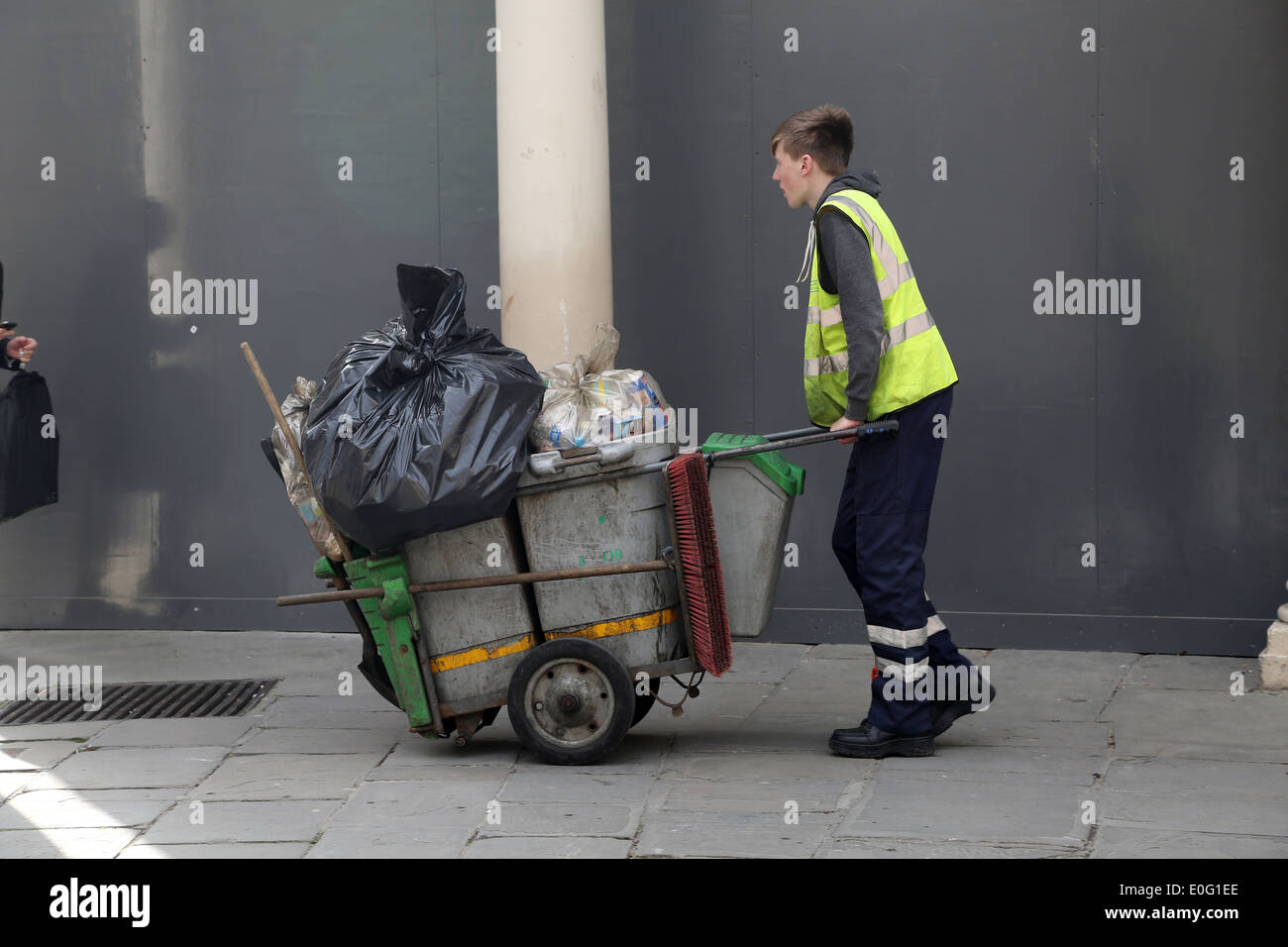 Young Street Sweeper dans la ville de Bath à la fin de la journée avec son panier plein. 10 avril 2014 Banque D'Images