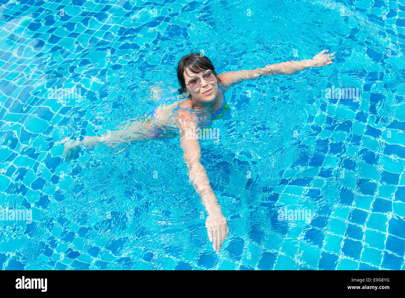 Portrait d'une belle jeune femme à lunettes flottant dans la piscine. Mode de vie sain photo Concept Banque D'Images