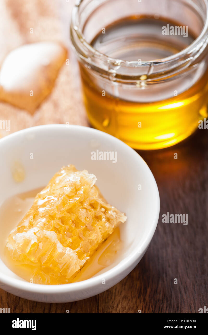 Pot de miel et d'abeilles sur fond de bois Banque D'Images