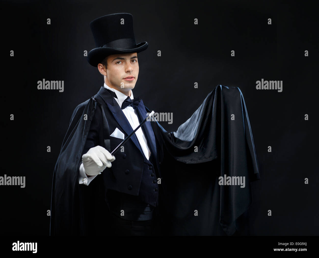Magicien dans top hat avec Magic wand montrant trick Banque D'Images