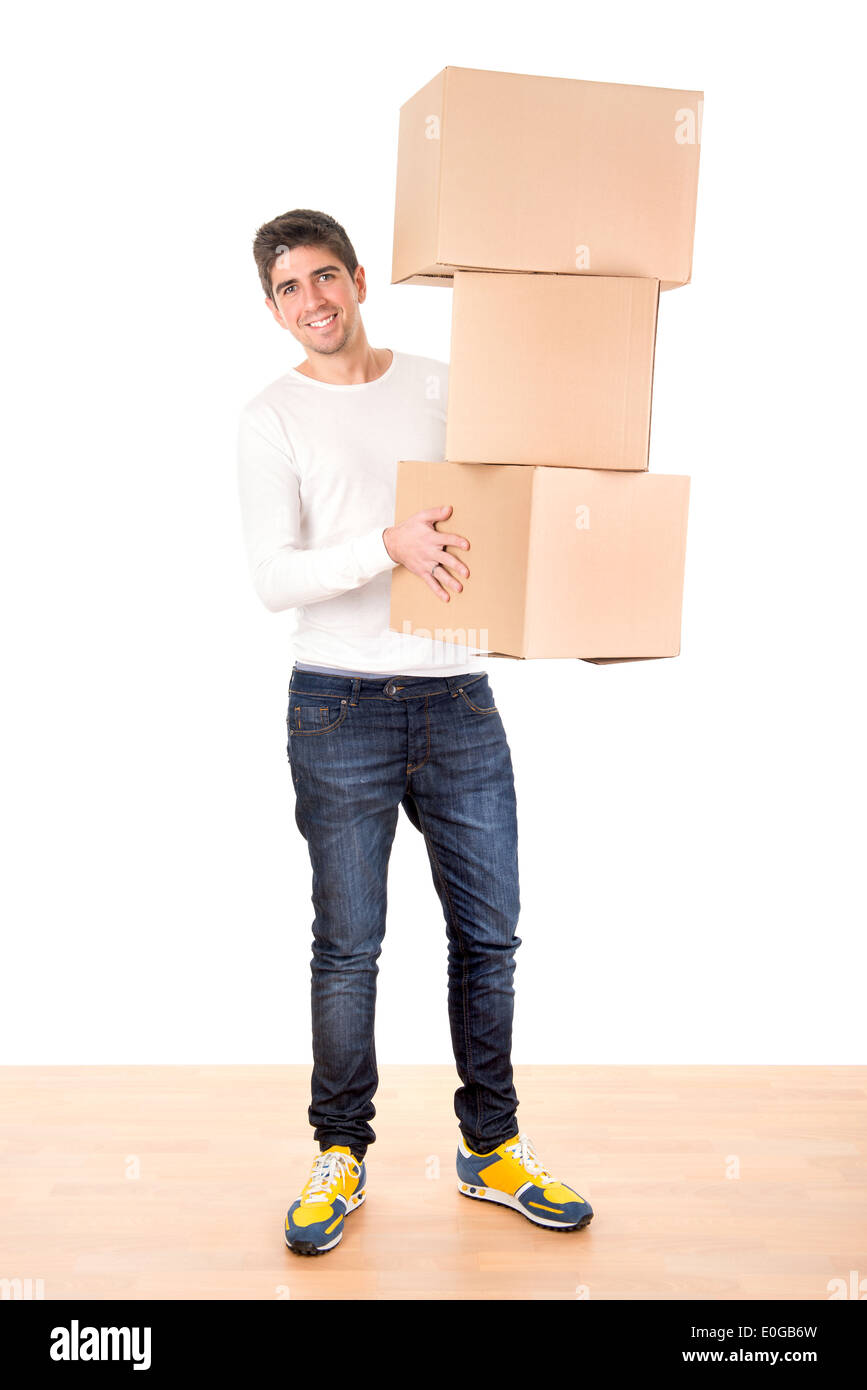 Beau jeune homme avec des boîtes de carton déballage in new home Banque D'Images