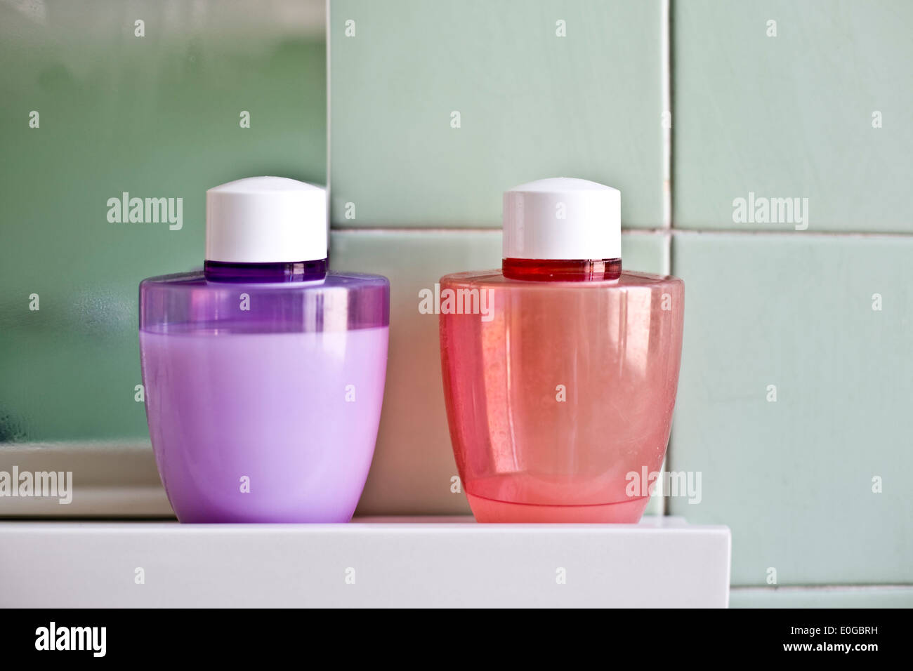 Violet et rose les bouteilles en plastique dans une salle de bain Banque D'Images