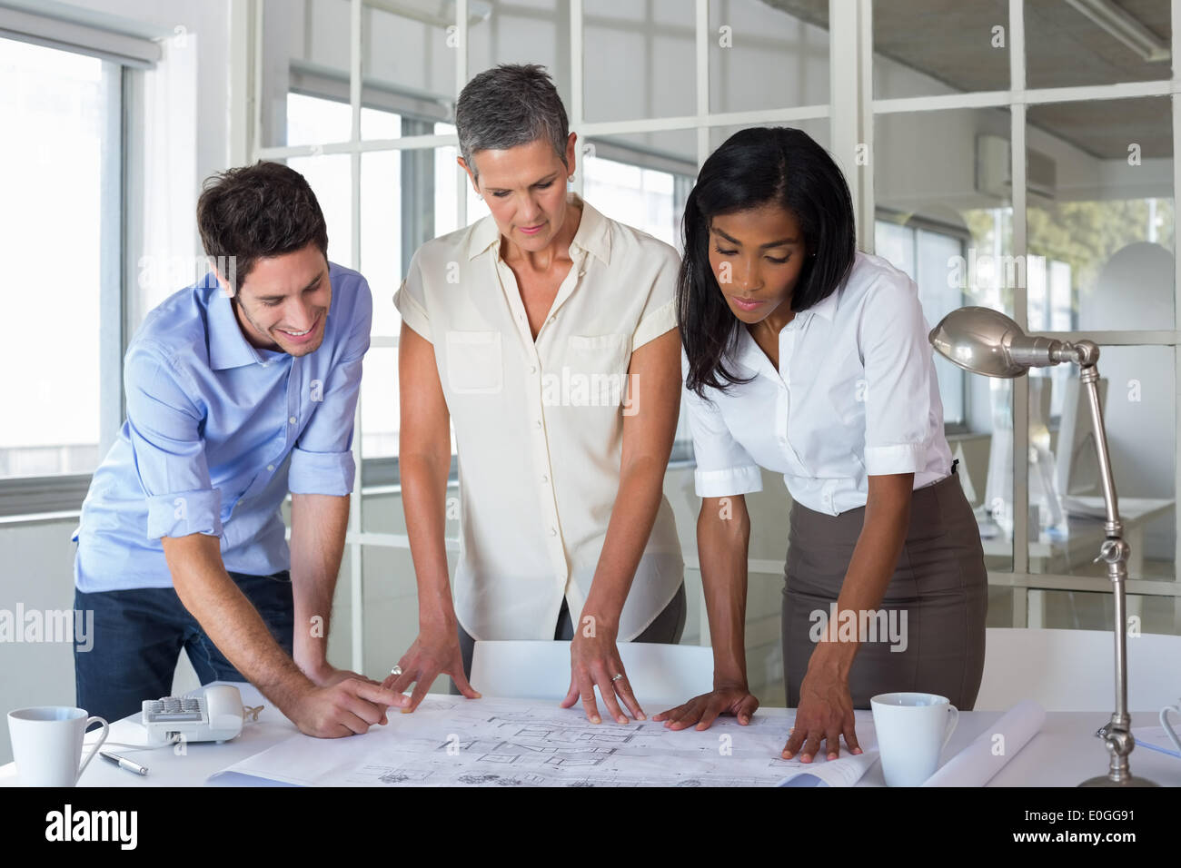 Équipe d'architectes looking at blueprints Banque D'Images